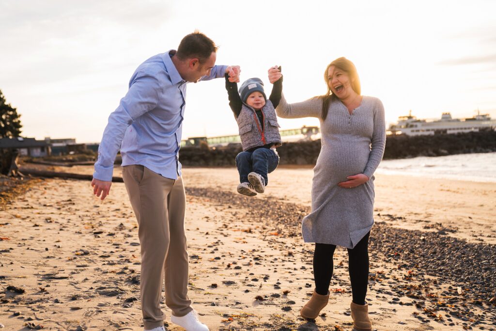 family swinging toddler boy during Seattle area maternity photos, Seattle Beach Maternity Photo