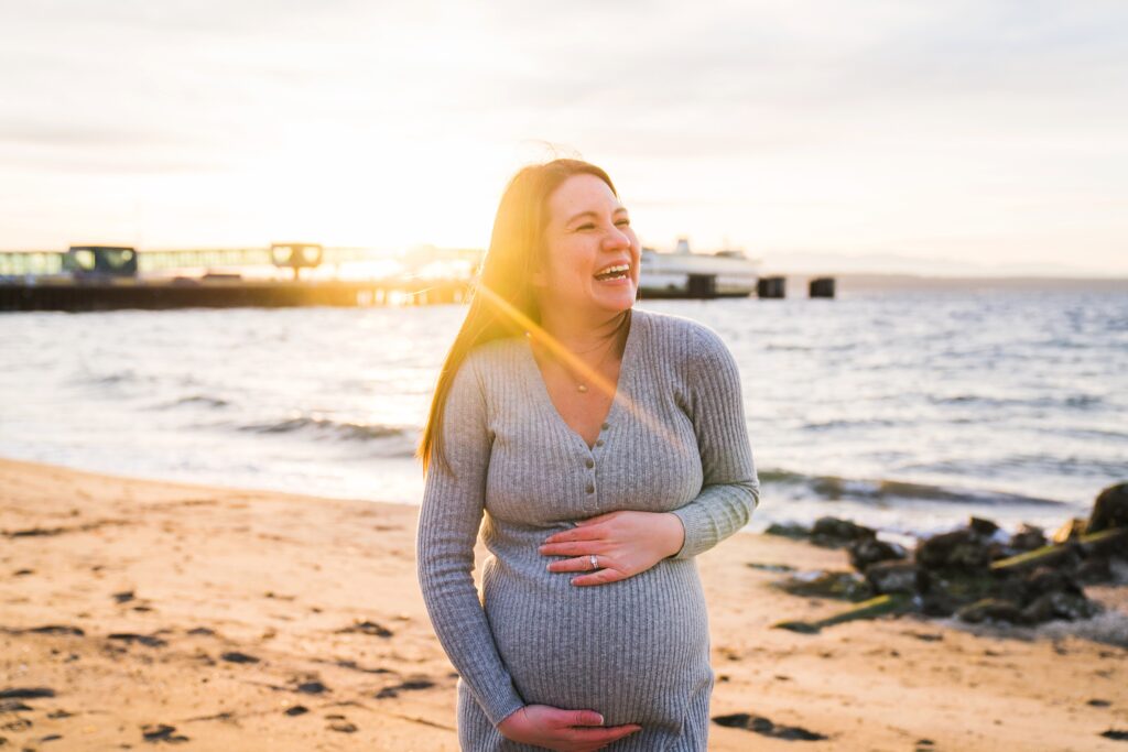 Avoiding awkward maternity photos with Snoqualmie maternity photographer, pregnant woman laughing at sunset at Brackett's Landing North Beach