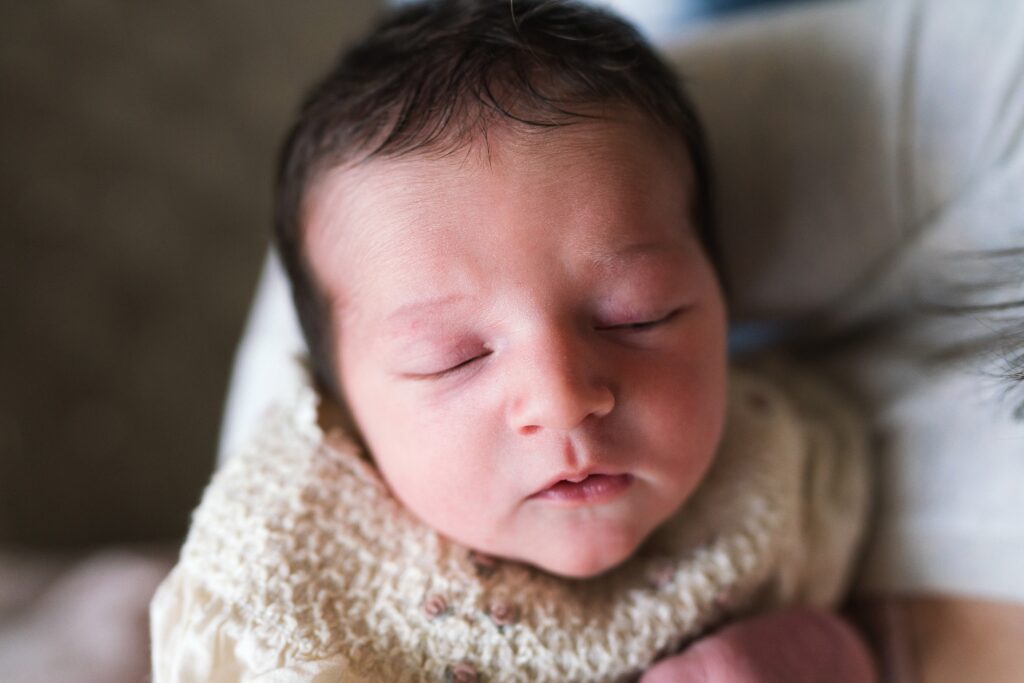 Newborn baby girl sleeping in mother's arms, Seattle newborn photography pricing 