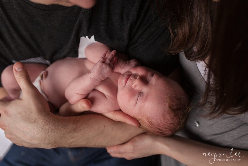 Newborn baby in father's arms by North Bend Photographer