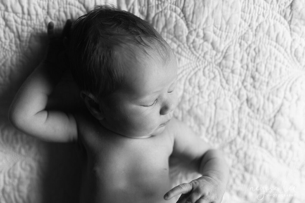 black and white photo of newborn baby sleeping on bed during North Bend, in-home newborn photography session
